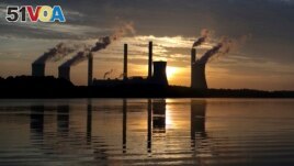 FILE - In this June, 3, 2017, file photo, the sun sets behind Georgia Power's coal-fired Plant Scherer, one of the nation's top carbon dioxide emitters, in Juliette, Ga. (AP Photo/Branden Camp, File)
