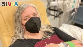 This photo provided by Amy Watson of Portland, Ore., shows her during an iron infusion in December 2022. Watson, approaching 50, says she has 