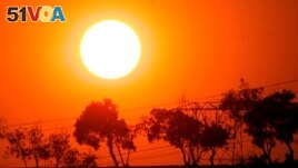 FILE - The sun sets as smoke from a wildfire creates an orange glow in the sky in Diamond Bar, Calif., Sunday, Nov. 16, 2008. (AP Photo/Marcio Jose Sanchez)