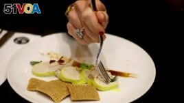 A woman eats 'Faux-gras', a vegan alternative to foie gras, in the restaurant 42 Degres in Paris France, December 15, 2022. (REUTERS/Sarah Meyssonnier)