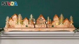This image provided by Balsam Hill shows their Christmas Mantel Village. The village is crafted of plywood and hand painted. With built-in lights, it's a charming Victorian-era decoration for mantels, windows or tabletops. (Balsam Hill via AP)
