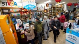 Madeline Copper, second from right, and her granddaughter, Lay-Lonnie, 5, stand in line to buy Powerball lottery tickets at the Wo Won Mini market in the Chinatown district of Los Angeles, Monday, Nov. 7, 2022. (AP Photo/Damian Dovarganes)