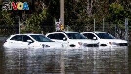 A trio of cars are stuck in floodwaters in Shepparton, Australia, Monday, Oct. 17, 2022. A flood emergency continues across parts of Australia's southeast. (Diego Fedele/AAP Image via AP)