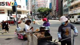 FILE - Women sell street food in Hong Kong, China November 6, 2019. (REUTERS/Thomas Peter)