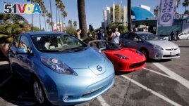 FILE - From left, electric cars from Nissan, Tesla, and Toyota are presented at a news conference in Los Angeles on Dec. 13, 2013. (AP Photo/Nick Ut, File)