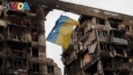 A view shows a torn flag of Ukraine hung on a wire in front an apartment building destroyed during Ukraine-Russia conflict in the southern port city of Mariupol, Ukraine April 14, 2022. (REUTERS/Alexander Ermochenko)