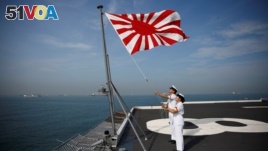 Sailors raise the Japanese naval ensign on the deck of Japanese helicopter carrier Kaga before its departure for naval drills in the Indian Ocean, near Jakarta Port, Indonesia September 22, 2018. (REUTERS/Kim Kyung-Hoon)