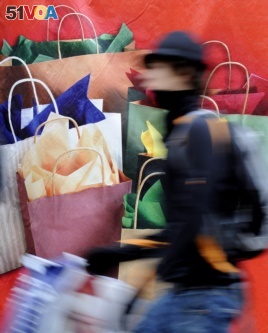 In this file photos, a man passes a banner with Christmas gifts in downtown Hamburg, Germany, on Saturday, Dec 20, 2008. (AP Photo/Fabian Bimmer)