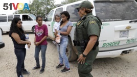 U.S. Border Patrol agent-in-charge Melissa Lucio, right, talks with women and children migrating from Honduras after they surrendered to U.S. Border Patrol agents after illegally crossing the border Monday, June 25, 2018, near McAllen, Texas. (AP Photo/Da