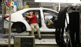 Technicians work on a Toyota Corolla assembly line, Blue Springs, Mississippi, Feb. 12, 2015.