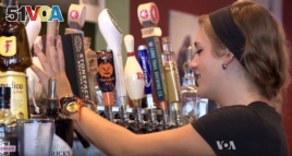 A bartender at Chris Tyll's restaurant pours a beer. Tyll does not think the government should require him to raise the wages of his employees.