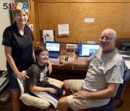 Mary and Bill Hill are pictured with their 8-year-old grandson Will in suburban Phoenix, Arizona. They oversee his distance learning. (Bill Hill via AP)