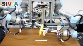 A dual-armed robot picks up a banana and peels it. Image taken December 2, 2021 and released by ISI (Kuniyoshi) Lab., School of Info. Sci & Tech., The University of Tokyo, Japan. (Handout via REUTERS)