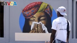 FILE - An image of a woman sneezing in a tissue serves as a reminder of preventive measure against COVID-19 at Cheikh Anta Diop University in Dakar on March 21, 2020. (Photo by Seyllou / AFP)