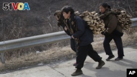 North Korean women carry firewood as they walk along a highway in Sinpyong county in North Hwanghae province, North Korea. There are concerns that new sanctions will hurt ordinary North Koreans.