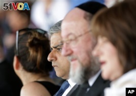 London's newly elected mayor, Sadiq Khan, center, sits with Ephraim Mirvis, Chief Rabbi of the United Hebrew Congregations of the Commonwealth, at the Yom HaShoah ceremony at Barnet Copthall Stadium in London, Sunday May 8, 2016. Khan joined an annual memorial to the millions of Jews slain in the Holocaust as his first official act as mayor. (Yui Mok/PA via AP)