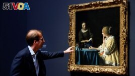 Director of Rijksmuseum Amsterdam Taco Dibbits looks at Vermeer's painting 'Mistress and Maid' at an exhibition bringing together 28 works by Dutch painter Johannes Vermeer in Amsterdam, Netherlands February 6, 2023. (REUTERS/Piroschka van de Wouw)