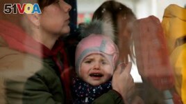 A Ukrainian child reacts as he boards a bus after arriving at Hendaye train station, southwestern France, Wednesday, March 9, 2022. (AP Photo/Bob Edme)