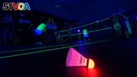 A badminton shuttlecock lit up in neon color at Shuttle in-the-dark badminton court in Kuala Lumpur, Malaysia, March 24, 2022. (REUTERS/Hasnoor Hussain)