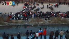FILE - Migrants gather at a crossing into El Paso, Texas, as seen from Ciudad Juarez, Mexico, Dec. 20, 2022. (AP Photo/Christian Chavez, File)