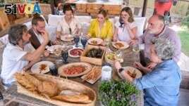 FILE - Diego Guerrero, from left, Carlos Sanchez, Mila, Ines Andres, Carlota Andres, Jose Andres and Pepa Mu<I>&#</I>241;oz enjoy a meal in a scene from the Discovery + television series Jose Andres and Family in Spain. (Xaume Olleros/Discovery via AP)