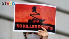 A woman holds up a sign while taking part in a demonstration about the use of robots by the San Francisco Police Department outside of City Hall in San Francisco, Monday, Dec. 5, 2022. (AP Photo/Jeff Chiu)