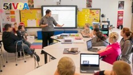 FILE - In this photo taken Feb. 12, 2015, sixth grade teacher Carrie Young guides her students through an exercise on their laptops. (AP Photo/Ty Wright) 