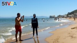 A woman, wearing a full-body burkini swimsuit, stands at a beach in La Marsa near Tunis, Tunisia September 11, 2022. (REUTERS/Jihed Abidellaoui)