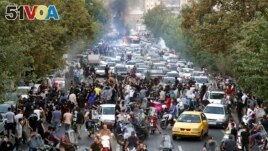 Protesters chant slogans during a protest over the death of a woman who was detained by the morality police, in downtown Tehran, Iran, Sept. 21, 2022, in this photo taken by an individual not employed by the Associated Press and obtained by the AP 