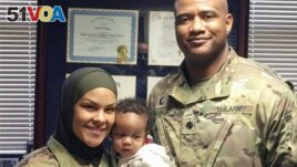 This undated photo provided by Army Col. Khallid Shabazz, right, in January 2022, shows him with with Spc. Savannah Spencer, who requested that Shabazz say a dua prayer for her baby. (Courtesy Khallid Shabazz via AP)