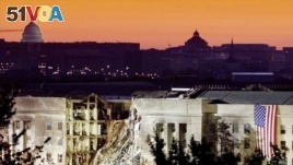 The damaged area of the Pentagon building, Islamic extremists flew a plane into it September 11, is seen in the early morning at sunrise with the U.S. Capitol Building in the background, September 16, 2001.