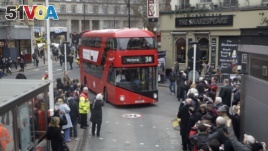 People take photos of the new routemaster double decker bus as it arrives at Victoria bus station in London on its first first day of service, Monday, Feb. 27, 2012. (AP Photo/Sang Tan)
