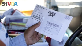 US Postal Service mail carrier Thomas Russell holds a census form while working his route in 2010.The U.S. Commerce Department has announced that the 2020 U.S. Census will include a question about citizenship status. (AP Photo/Jason E. Miczek)