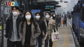 People wearing masks to protect from air pollution walk at a bus station in Seoul, South Korea, Wednesday, March 6, 2019. (AP Photo/Ahn Young-joon)