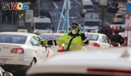 Due to air pollution in Madrid, a traffic policeman wears a mask while directing traffic, Dec. 29, 2016.