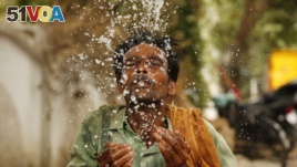 An Indian worker splashes water on his face to cool himself on a hot summer afternoon in Prayagraj, Uttar Pradesh, India, Thursday, June 13, 2019.