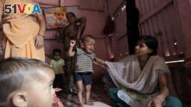 A volunteer weighs a malnourished child in Mumbai, India. A new study indicates in the same way that lack of food can harm children, violence, deprivation and neglect are also damaging their brain circuitry. (AP Photo/Rajanish Kakade)