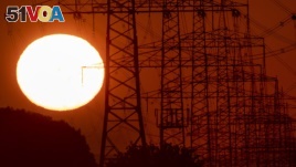 The sun rises next to power lines in Frankfurt, Germany, Tuesday, June 23, 2020. (AP Photo/Michael Probst)