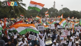 Indians hold national flags and placards during a protest organized by several Muslim organizations against a new citizenship law that opponents say threatens India's secular identity in Bangalore, India, Monday, Dec. 23, 2019. (AP Photo/Aijaz Rahi)