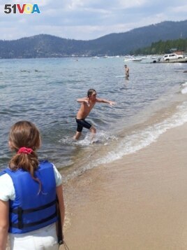 James leaves the water after completing a 12-hour swim across the entire length of Lake Tahoe. (AP Photo/Jillian Savage)