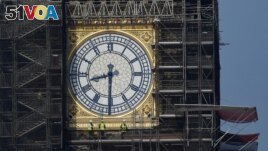 FILE - Workers stand on scaffolding underneath one of the clock faces on the Elizabeth Tower, more commonly known as Big Ben, as renovation works continue at the Houses of Parliament, London, Britain, September 6, 2021. (REUTERS/Toby Melville/File Photo)