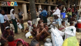 Rohingya internally displaced persons wait for aid after a cyclone in a camp in Myanmar.