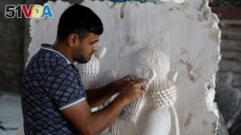 The sculptor Khaled al-Abadi works inside his workshop on his sculptures which depict scenes from the history of the city of Mosul, in Mosul, Iraq, September 15, 2022. (REUTERS/Khalid al-Mousily)