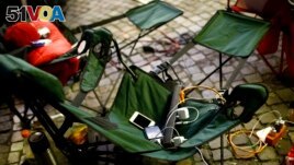 Power cords and battery chargers for Apple devices are seen on a foldable chair as people camp outside an Apple store in Franfurt, Germany. (FILE - REUTERS/Kai Pfaffenbach)