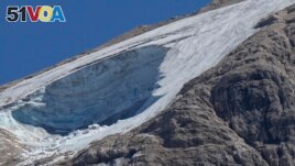 A rescue helicopter hovers over the Punta Rocca glacier near Canazei, in the Italian Alps in northern Italy, July 4, 2022, a day after a huge chunk of the glacier broke loose, sending an avalanche of ice, snow, and rocks onto hikers.