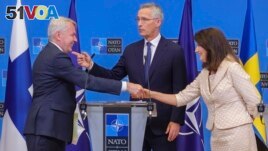 Finland's Foreign Minister Pekka Haavisto, left, Sweden's Foreign Minister Ann Linde, right, and NATO Secretary General Jens Stoltenberg after the signature of the NATO Accession Protocols for Finland and Sweden on July 5, 2022. (AP Photo/Olivier Matthys)