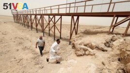 Iraqis visit an area near the pond remaining of Lake Sawa, due to climate change-induced drought, in Samawa city, Iraq May 1, 2022. (REUTERS/Alaa Al-Marjani)