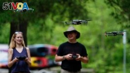 Quincey Johnson, left, and Martin Lively, fly their drones during a training session, Tuesday, June 7, 2022, in Poolesville, Md. (AP Photo/Julio Cortez)