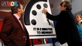 Members of the Bulletin of the Atomic Scientists, (L-R), Lawrence Krauss, Robert Rosner and Sharon Squassoni move the 'Doomsday Clock' hands to two minutes until midnight at a news conference in Washington, Jan. 25, 2018. (REUTERS/Leah Millis)