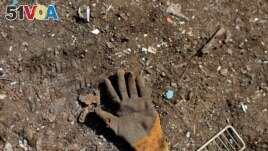A glove left behind by a Palestinian worker is seen on the ground at a metal waste junkyard. The picture was taken January 25, 2021. REUTERS/Mohammed Salem